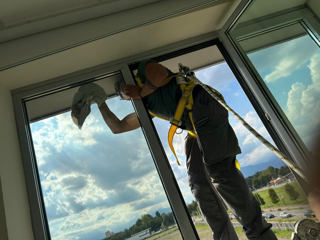Operatore Diamond Clean in sicurezza durante la pulizia di vetrate di un ufficio a Torino